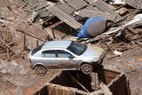 A car balances on a building in Bento Rodigues district after the dam burst caused a mudslide.