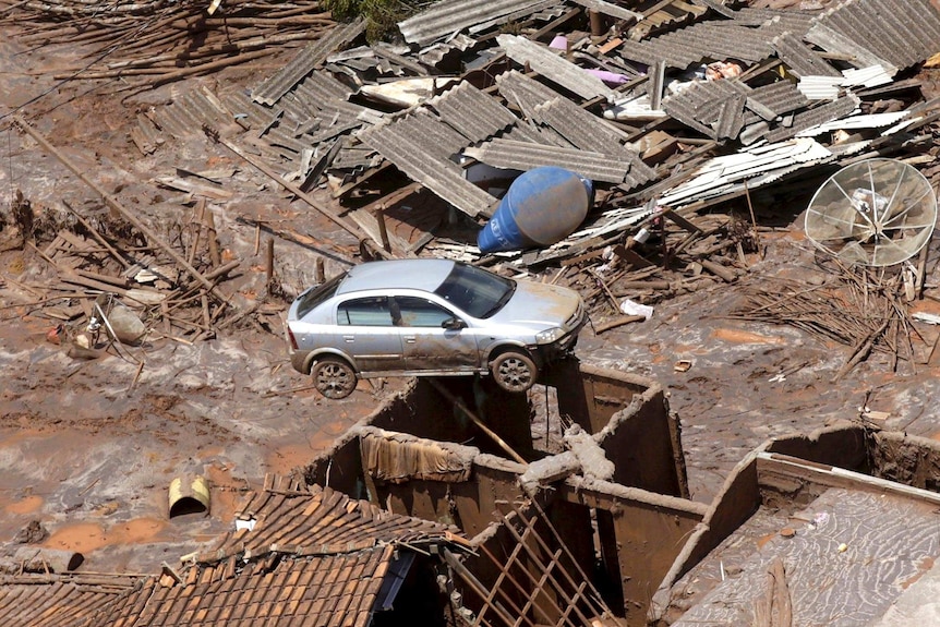 A car balances on a building in Bento Rodigues district after the dam burst caused a mudslide.