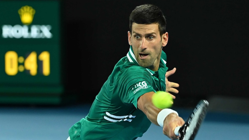 Novak Djokovic extends to strike a backhand return against Alexander Zverev at the Australian Open.