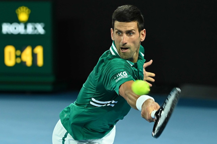 Novak Djokovic stretches out to hit a backhand return against Alexander Zverev at the Australian Open.