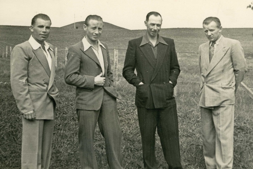 Bronius Srederas stands with three other man in a paddock.