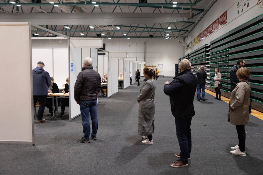 People line up to vote at a local sports complex in Kopavogur, Iceland