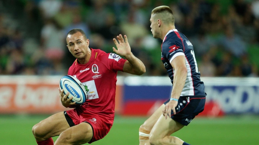 Queensland five-eighth Quade Cooper attempts to sidestep the Rebels' James O'Connor.