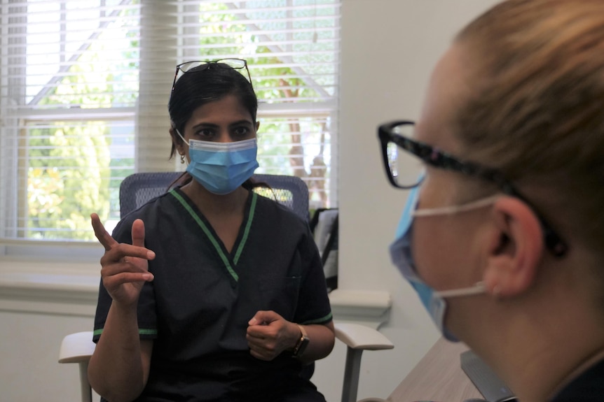 A doctor consults a patient in a clinic