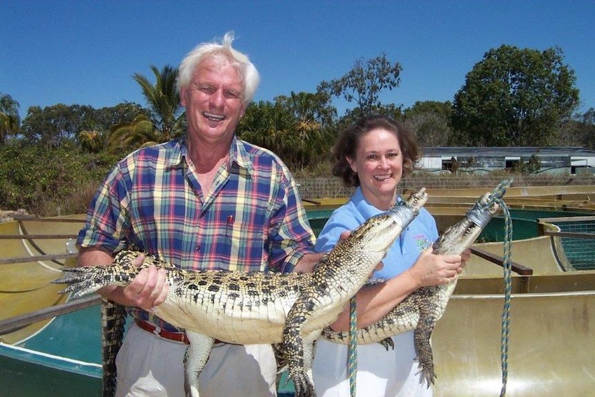 John Lever and Lillian Lever hold two small crocs while smiling for the camera.