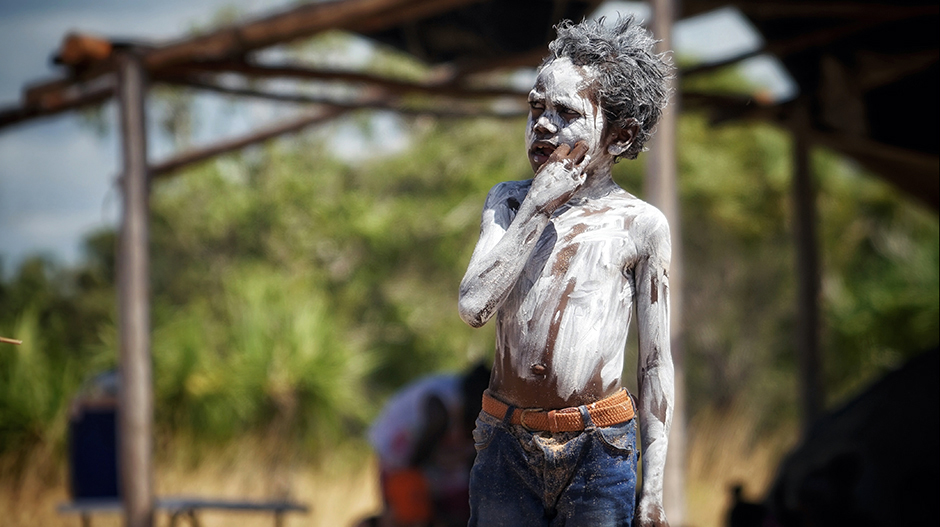 A child is dressed in jeans and traditional paints