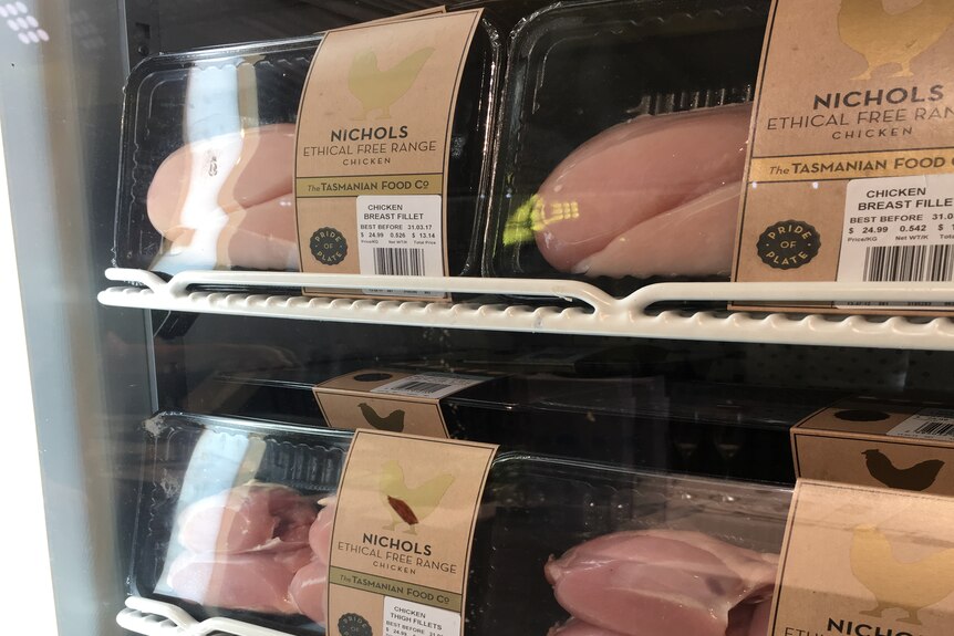 Supermarket shelves filled with trays of chicken