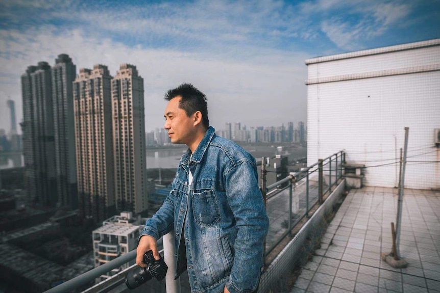 A man taking photos on a roof top