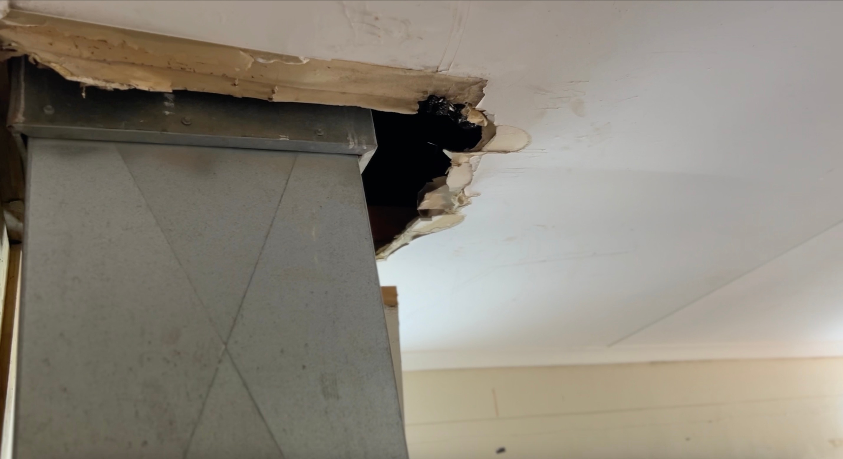 Um telhado quebrado em torno de um conduíte de metal.