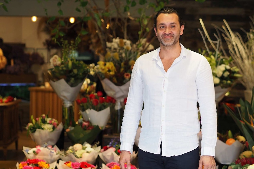 Sydney florist george pizanis standing in front of an arrangement of flowers