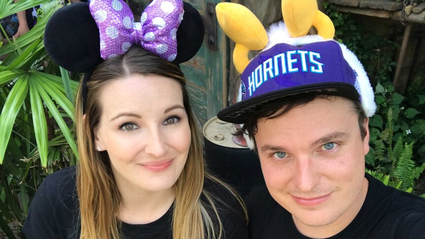 Keira wears Minnie Mouse ears and Matt wears a "hornets' hat with fake antennae on top.