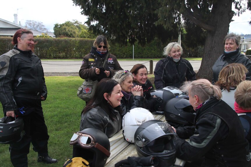 Women in motorcycle gear meet.