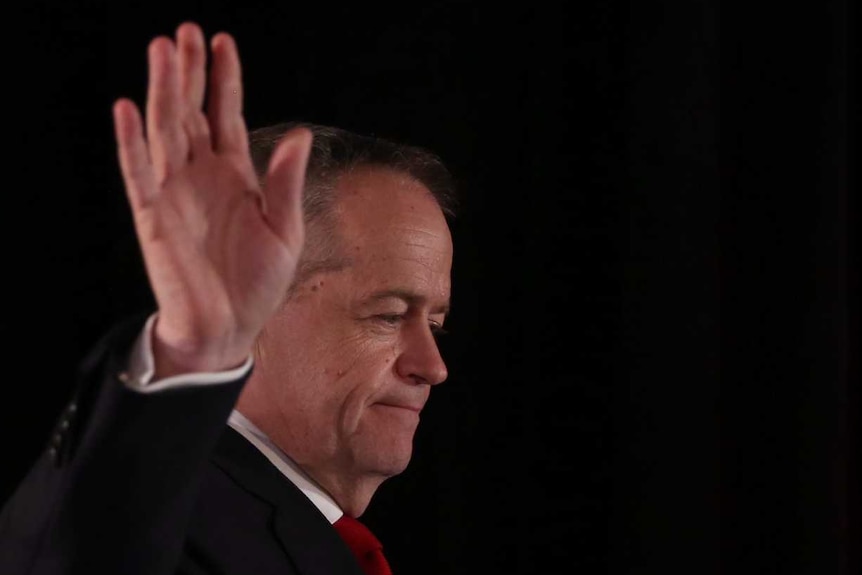 Bill Shorten waves as he walks onto the stage on the night of the federal election.