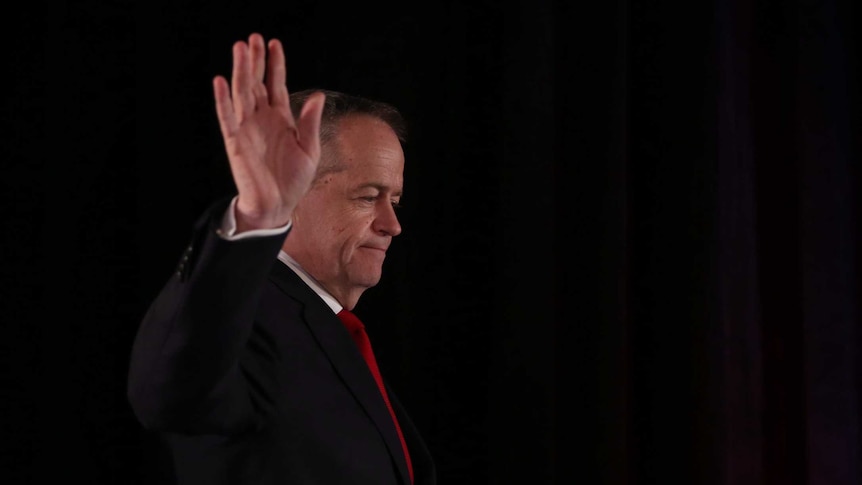 Bill Shorten waves as he walks onto the stage on the night of the federal election.