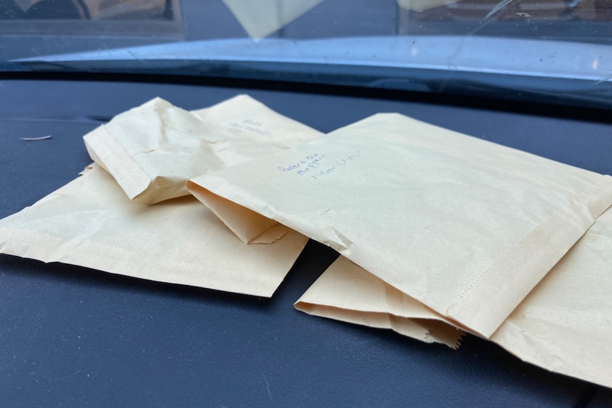 A pile of brown paper bags sitting on the dash of a car