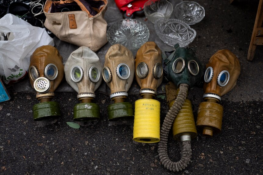 Several Soviet-era gas masks are laid out on the ground