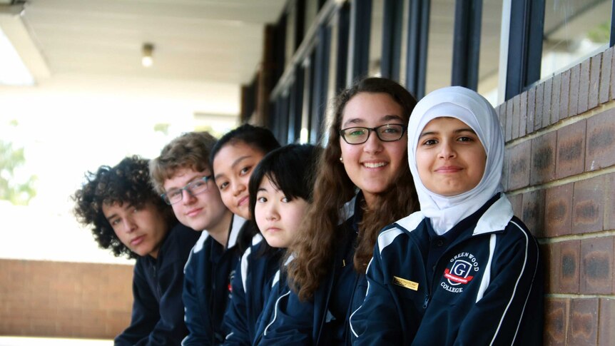 Debating team members lined up on a bench at the school.