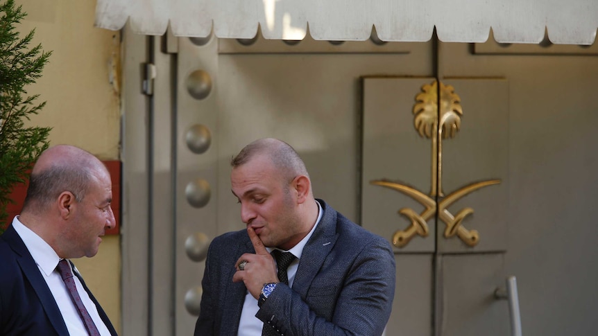 Members of the security team stand outside the Saudi Arabia consulate in Istanbul. The entrance is a big metal closed door.