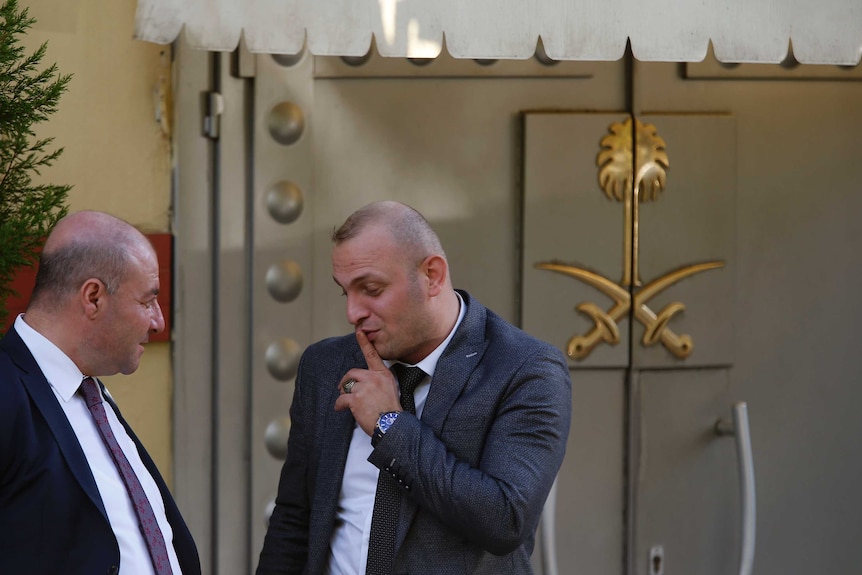 Members of the security team stand outside the Saudi Arabia consulate in Istanbul. The entrance is a big metal closed door.