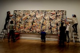 Staff at the National Gallery of Australia rehang Jackson Pollock's Blue Poles artwork.