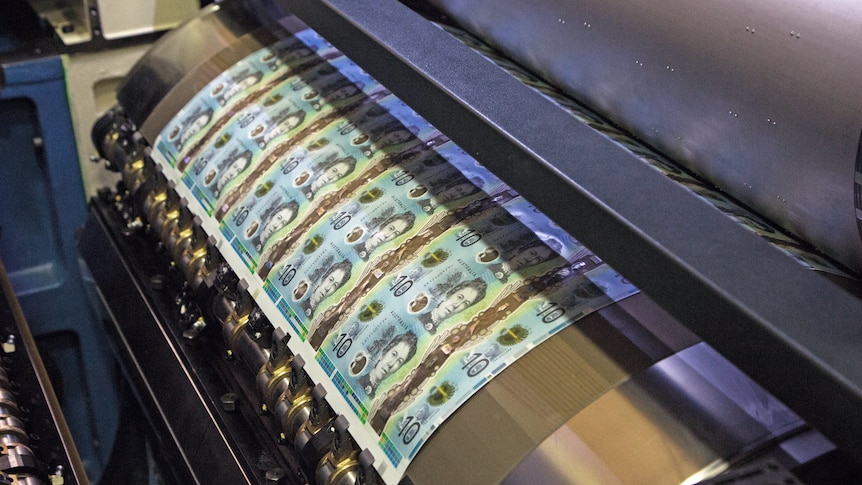 A feed of 10 dollar notes moves through a press, wound around a reel.