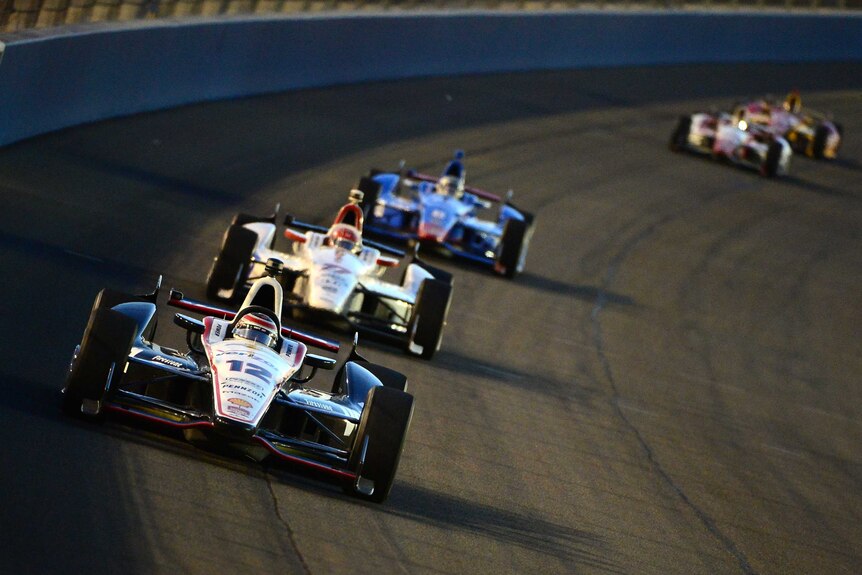 Australia's Will Power (#12) from Team Penske, leads a row of cars in the last IndyCar race of 2014.