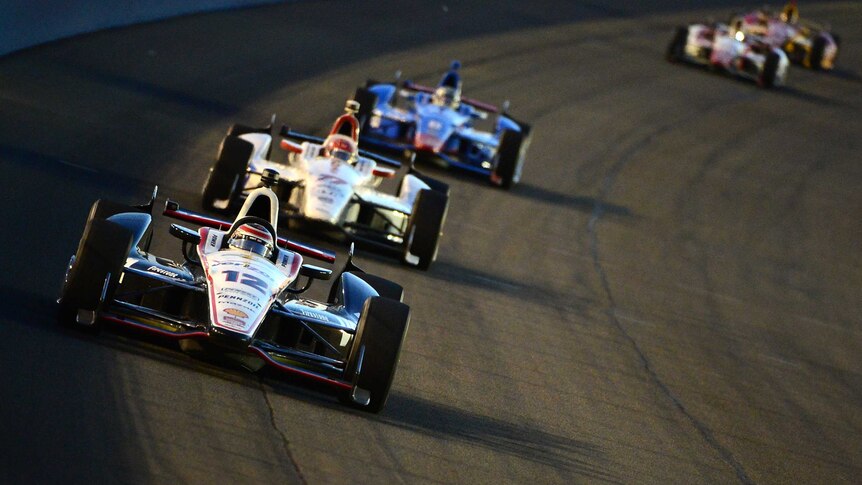 Australia's Will Power (#12) from Team Penske, leads a row of cars in the last IndyCar race of 2014.