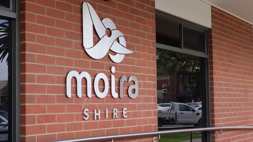 A brick wall bearing metallic lettering that says "Moira Shire".