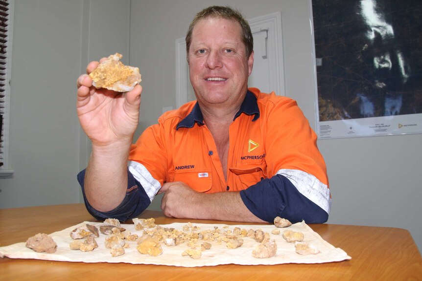 A mine worker holds up gold nuggets found near Kalgoorlie in Western Australia