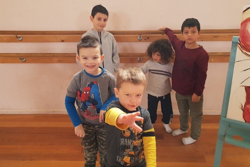 Five young boys learning to dance in dance studio.