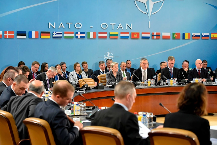 NATO secretary-general Jens Stoltenberg speaks to a round table meeting of NATO members.