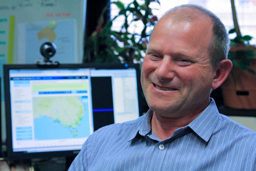 Man smiling with a window with blinds behind him