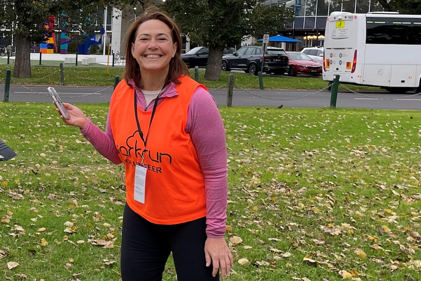 Lisa Millar smiles while wearing a parkrun volunteer vest.