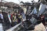 Iraqi men look at the damage following a bomb explosion in a market in Baghdad