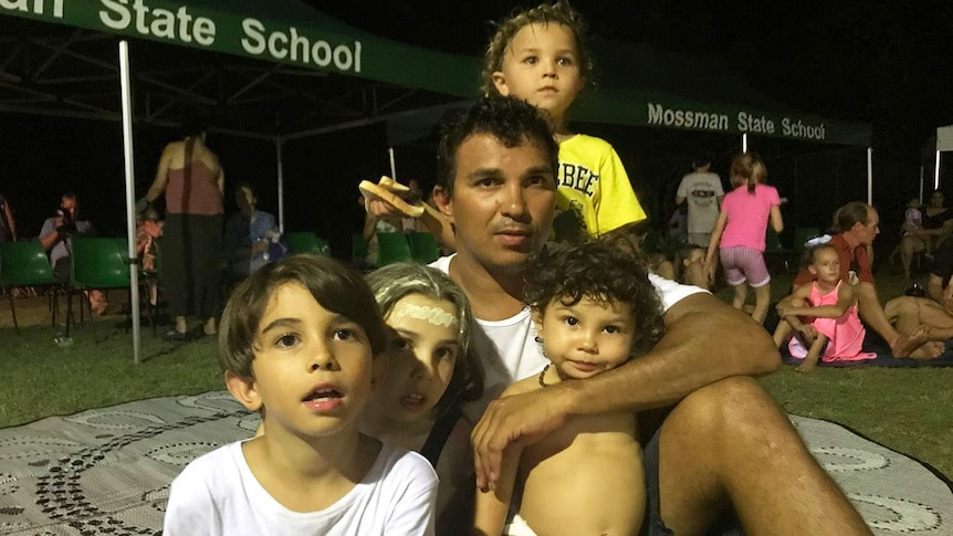 Kuku Yalinji parent Juan Walker sits with his family in Mossman in far north Queensland in December 2018