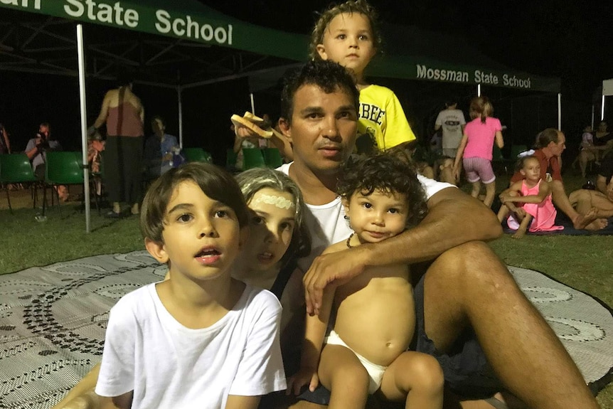 Kuku Yalinji parent Juan Walker sits with his family in Mossman in far north Queensland in December 2018