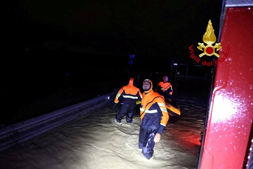 Emergency crews wade through flood waters 