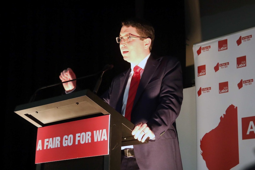 Patrick Gorman stands at the podium delivering his victory speech.