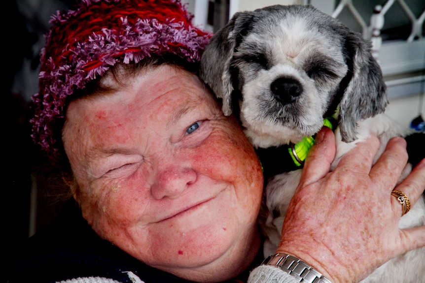 A close up photo of a woman and her small dog.