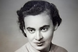A vintage portrait of a woman looking at the camera with dark brown eyes and dark hair.
