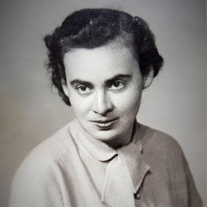 A vintage portrait of a woman looking at the camera with dark brown eyes and dark hair.