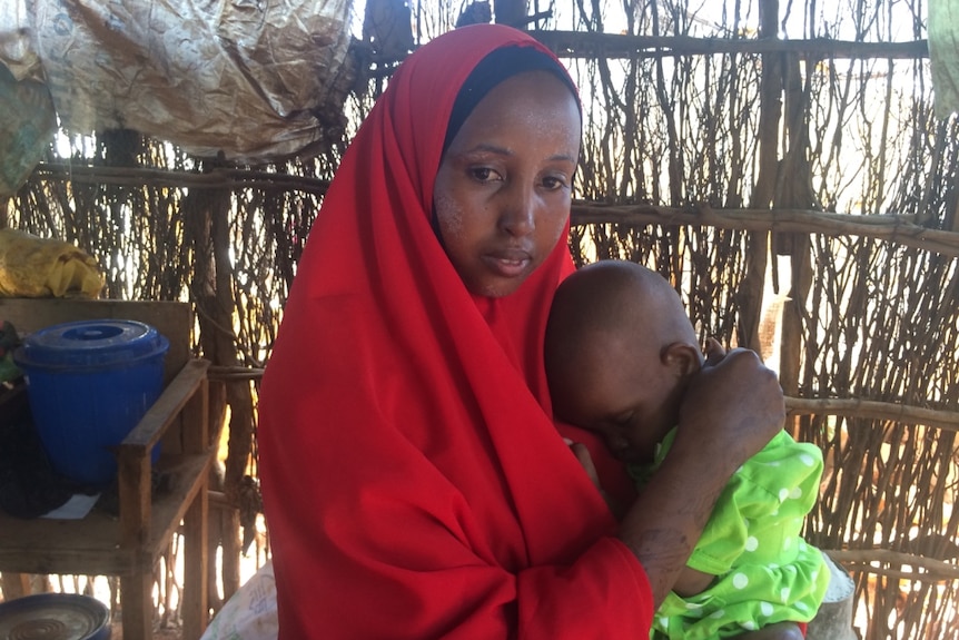 A woman cradles her baby.