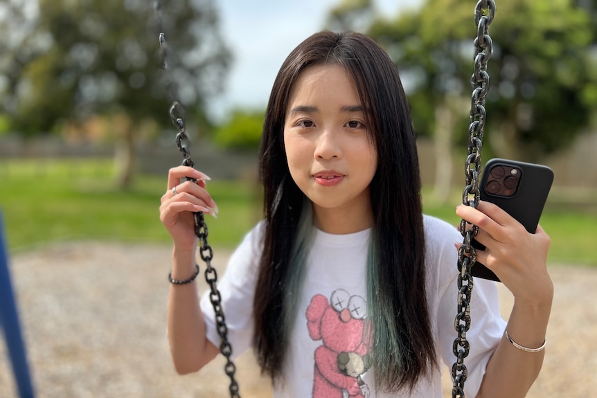 Sally Liu sits on a swing.