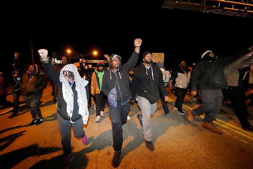 Protesters hold fists in the air as they march in Memphis.
