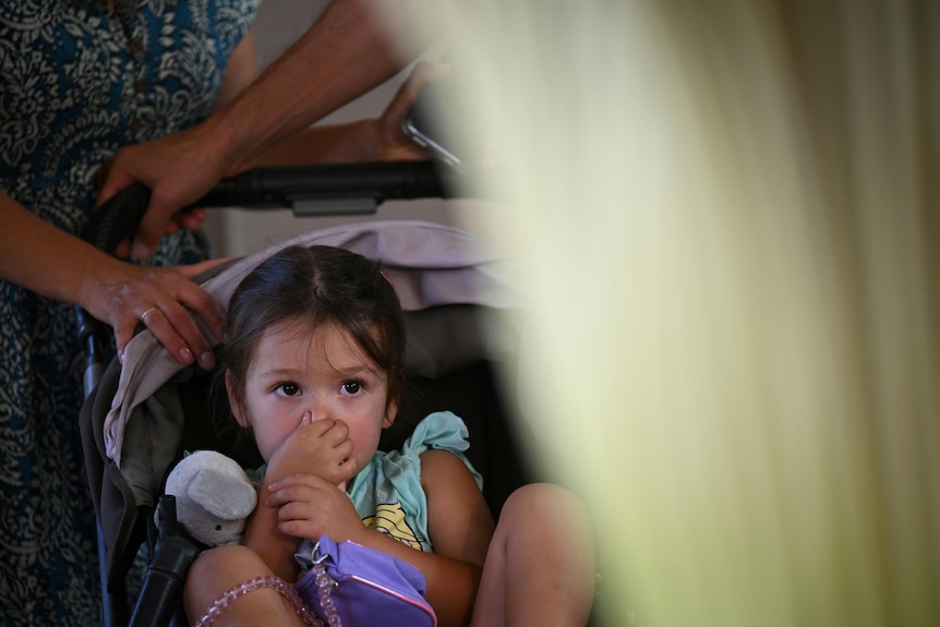 A child holds their nose while viewing the corpse flower.