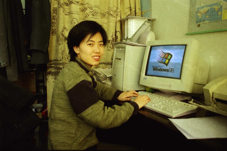 A woman pictured with a computer loading a Windows 98 screen