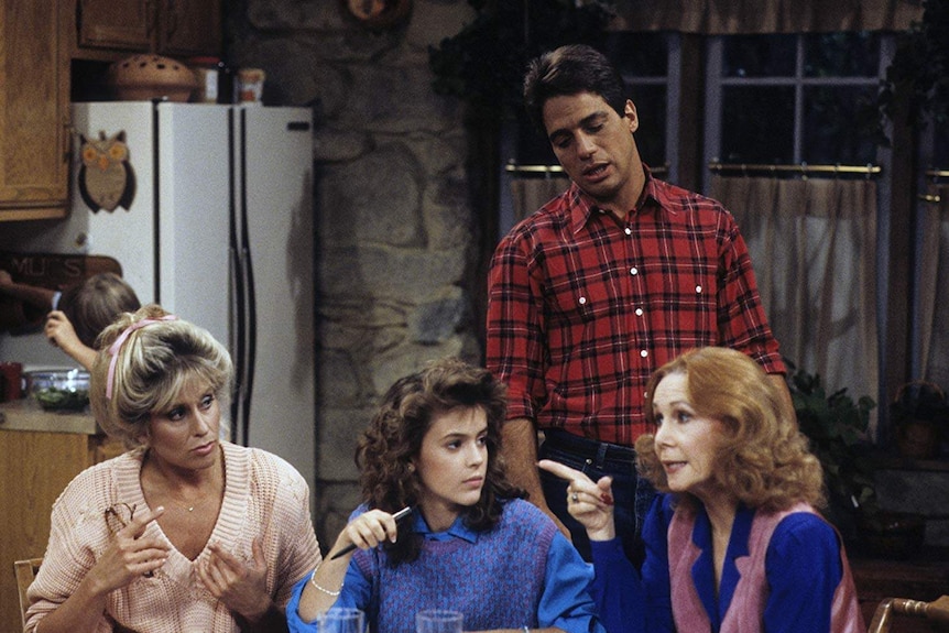 Scene from Who's The Boss with Judith Light, Alyssa Milano and Katherine Helmond sitting at a table and Tony Danza standing