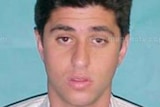 Mugshot of a young man with dark hair and brown eyes.