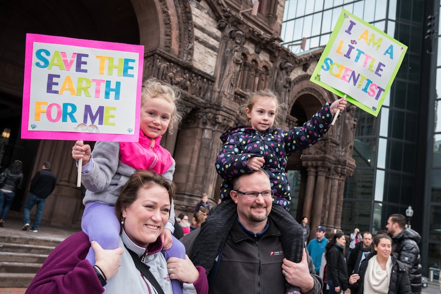 A family with their signs at the Stand up for Science rally in Boston