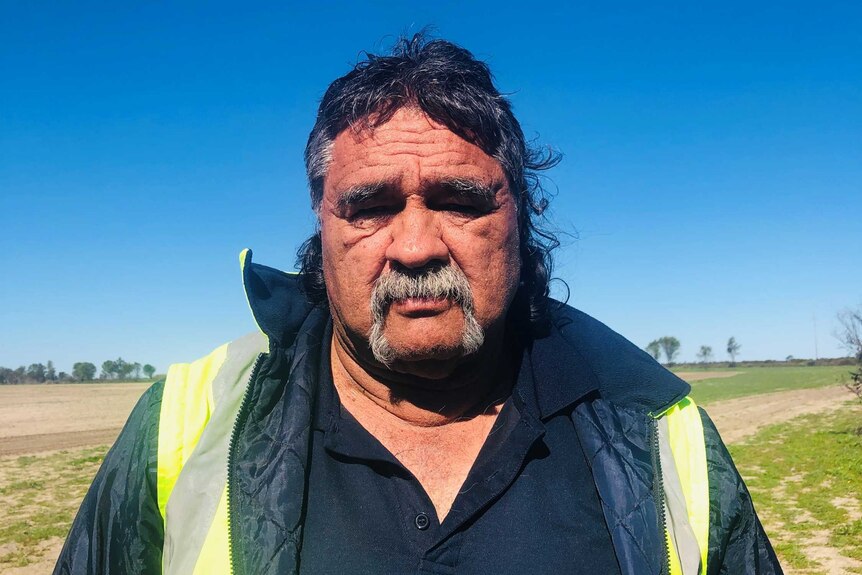 Portrait of an Aboriginal man with a greying moustache.